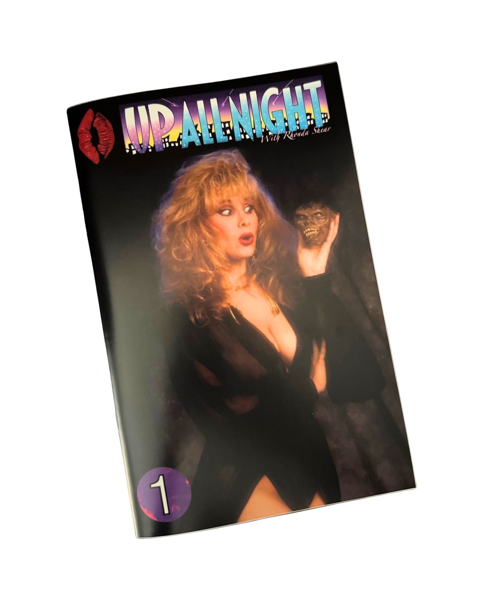 Comic book titled 'Up All Night' with a cover featuring Rhonda Shear holding a tiny zombie head in a dark setting.
