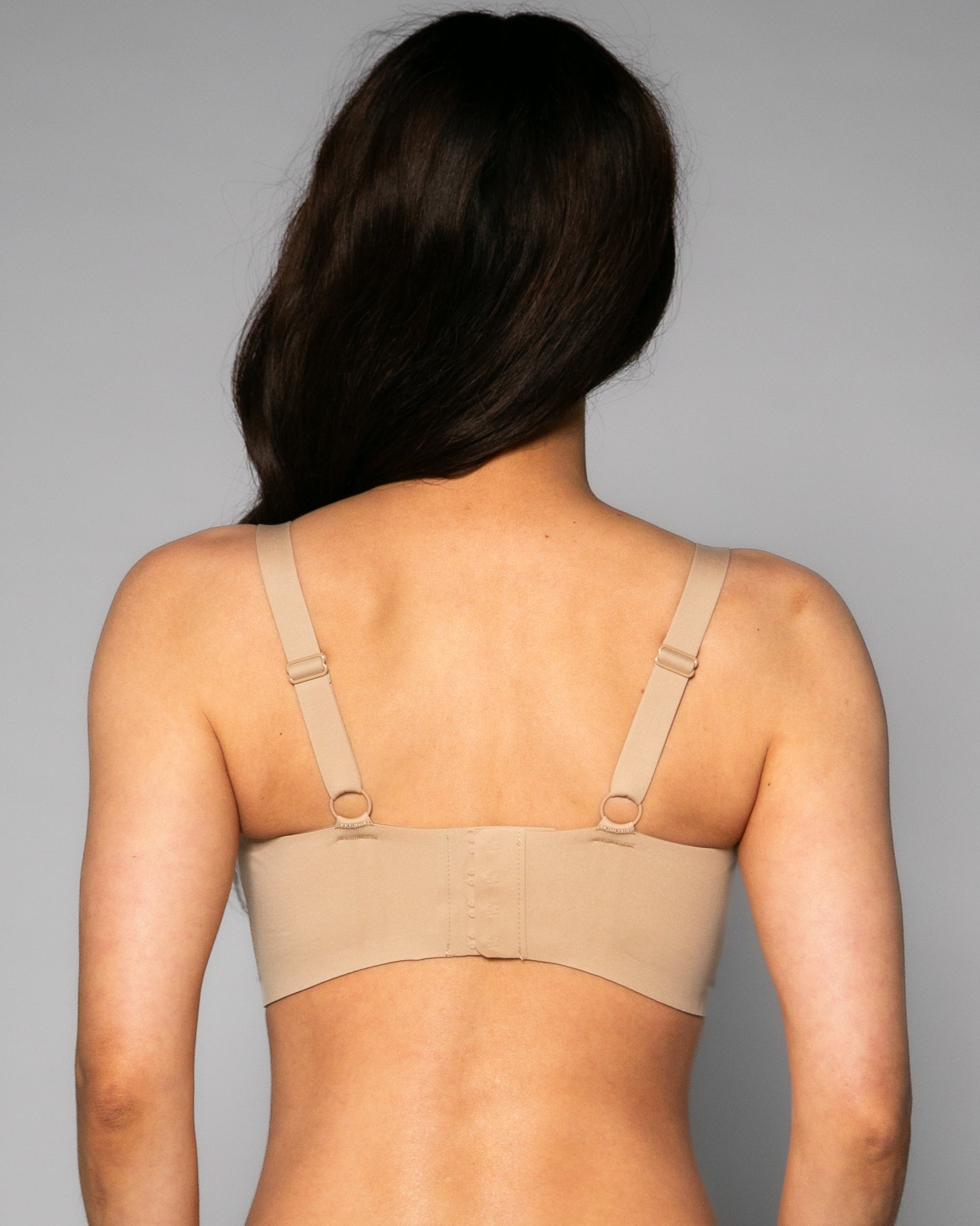 Back view of a woman wearing a beige Gel Bra with Lace Detail and Back Closure bra against a gray background