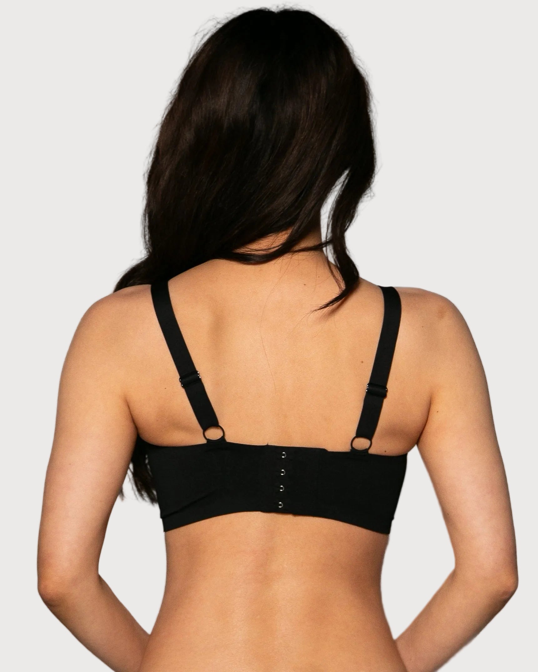 Back view of a woman wearing a black Gel Bra with Lace Detail and Back Closure bra against a gray background