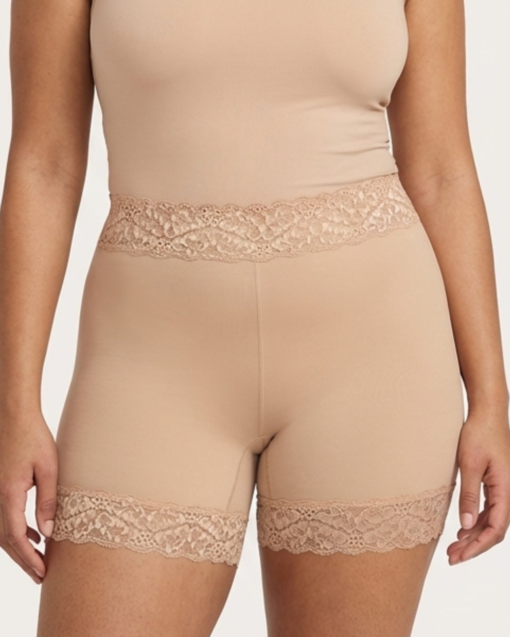 Woman wearing the Seamless Lace Boyshorts in beige on a plain background