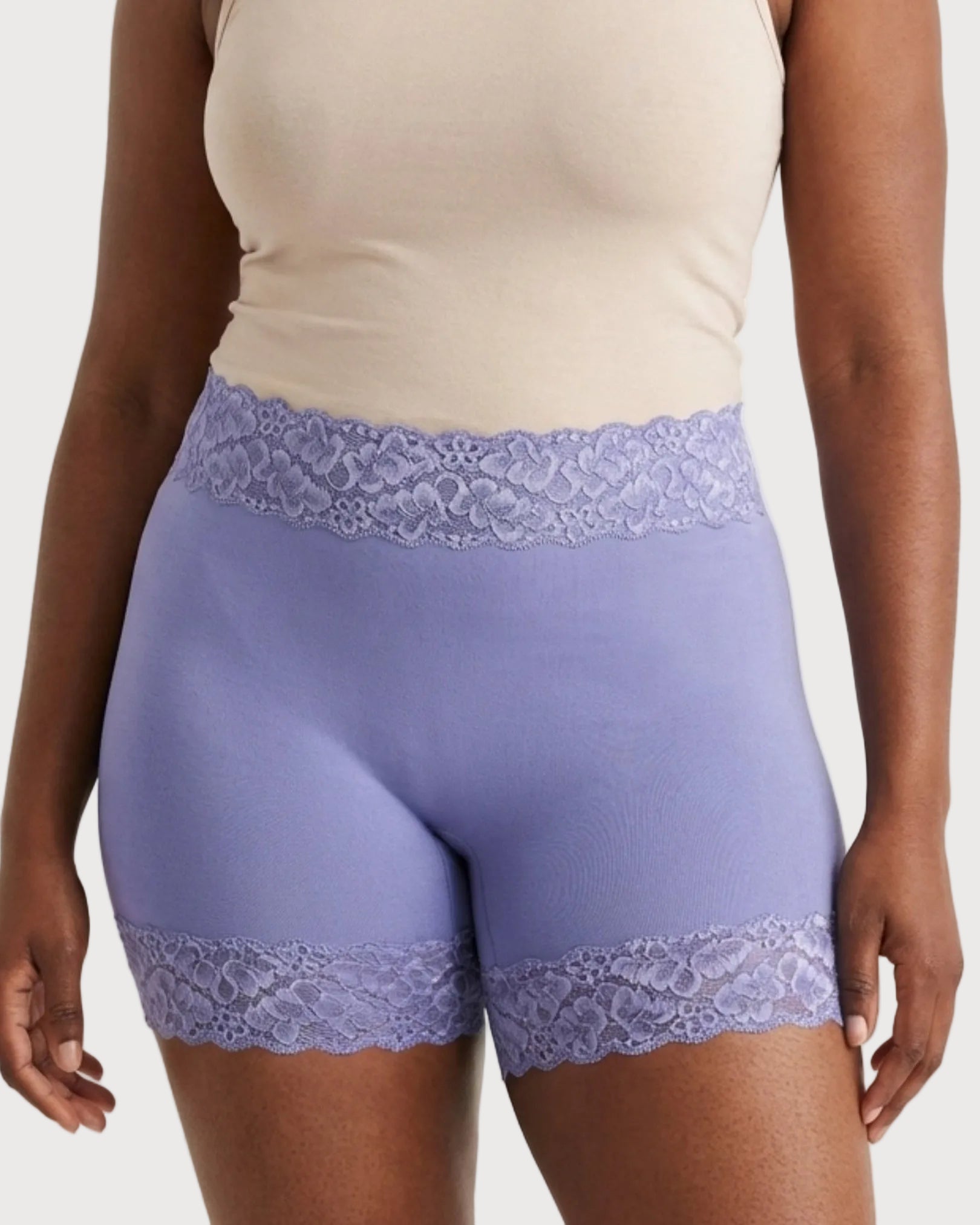 Woman wearing the Seamless Lace Boyshorts in purple on a plain background