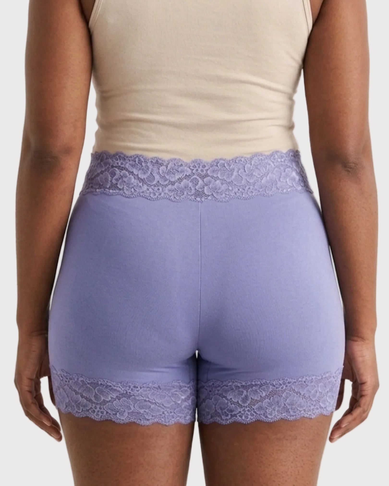 The backside of a woman wearing the Seamless Lace Boyshorts in purple on a plain background