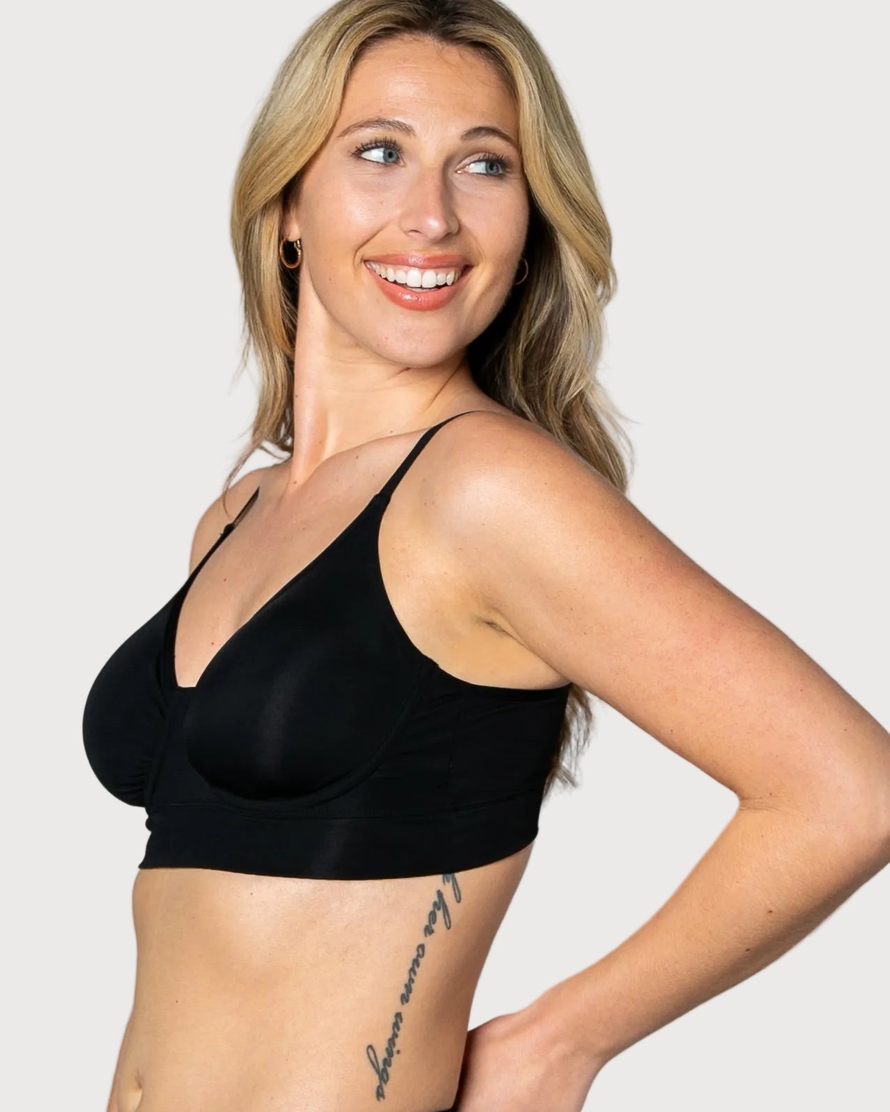 3/4 view of a woman wearing a black No Wire Underwire bra and panties set against a gray background