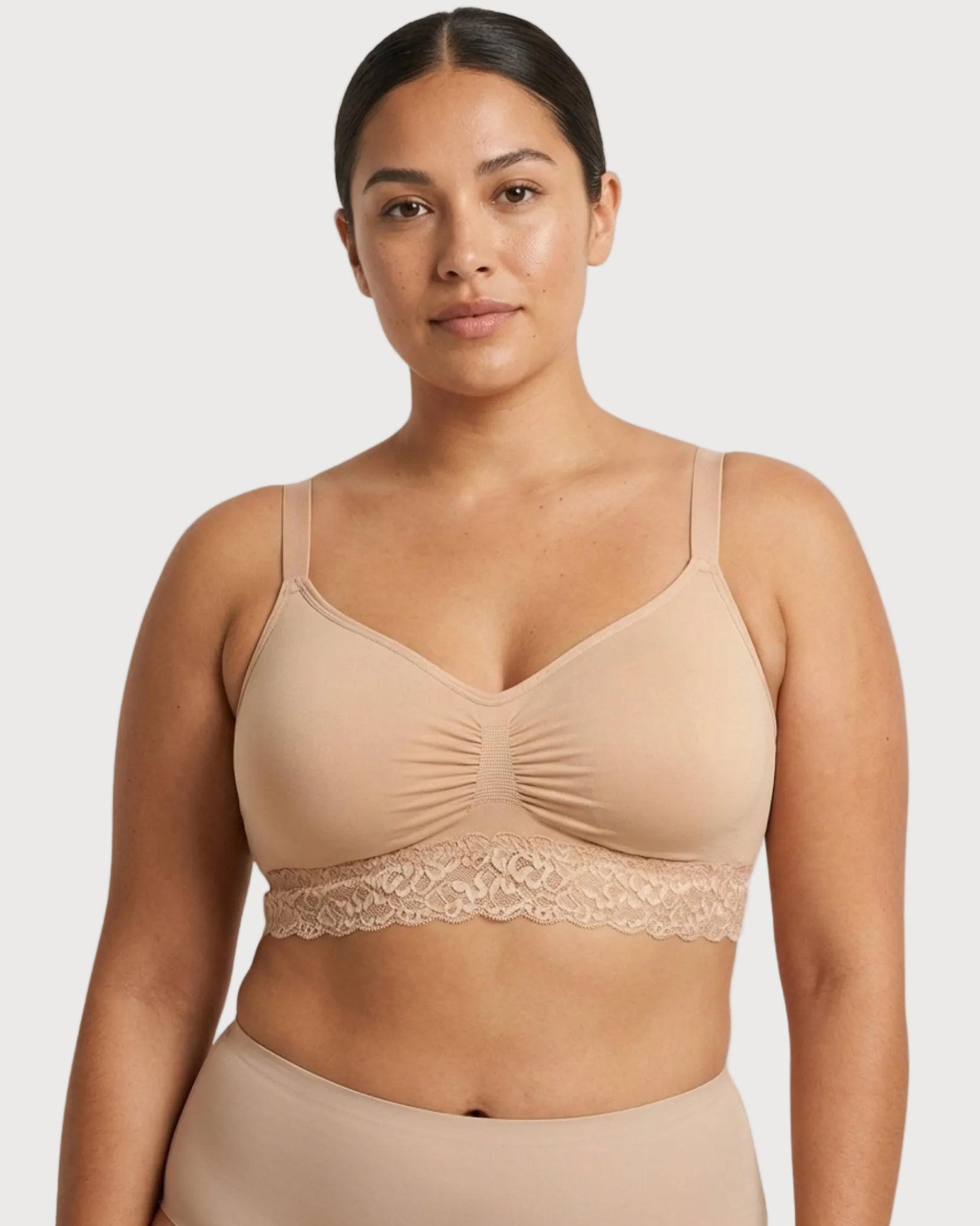 Woman wearing a beige Seamless Bra with lace Band on a plain background