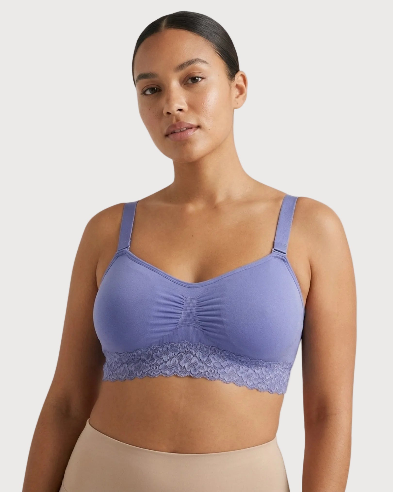 Woman wearing a purple Seamless Bra with lace Band against a plain background