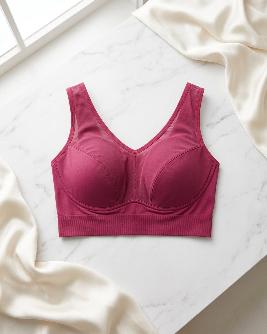 A beet Mesh Front Leisure Bra, laid flat on a white marble surface with draped cream satin fabric in the corners.