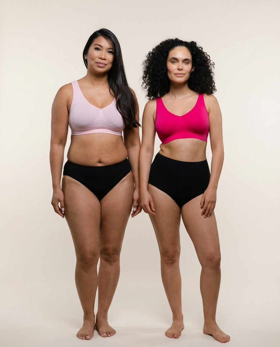 Two women wearing black high-waisted bikini bottoms and colorful sports bras on a beige background