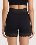 The backside of a woman wearing the Seamless Lace Boyshorts in beige on a plain background