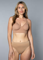 Woman wearing a beige No Wire Underwire bra and panties set against a gray background