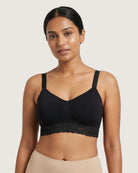 Woman wearing a black Seamless Bra with lace Band against a plain background