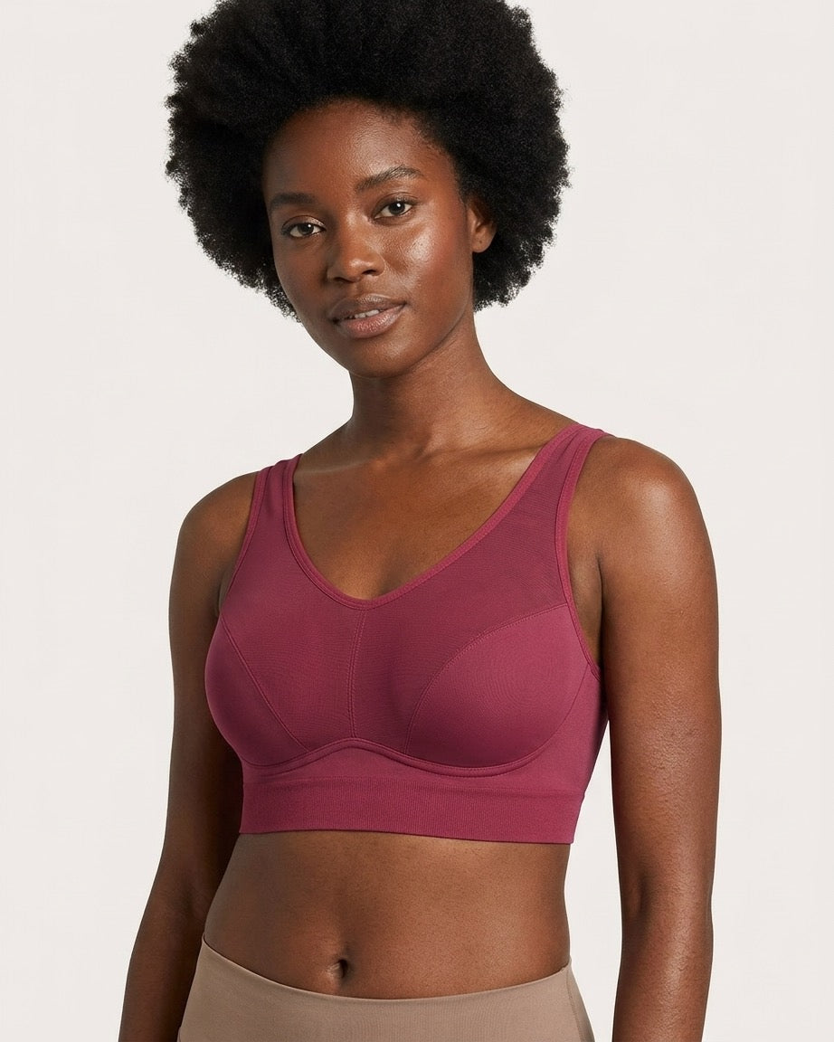 A woman wearing a beet Mesh Front Leisure Bra, shown from the waist up against a light off-white background.