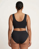A woman viewed from the back wearing a black Mesh Front Leisure Bra against a plain light background.